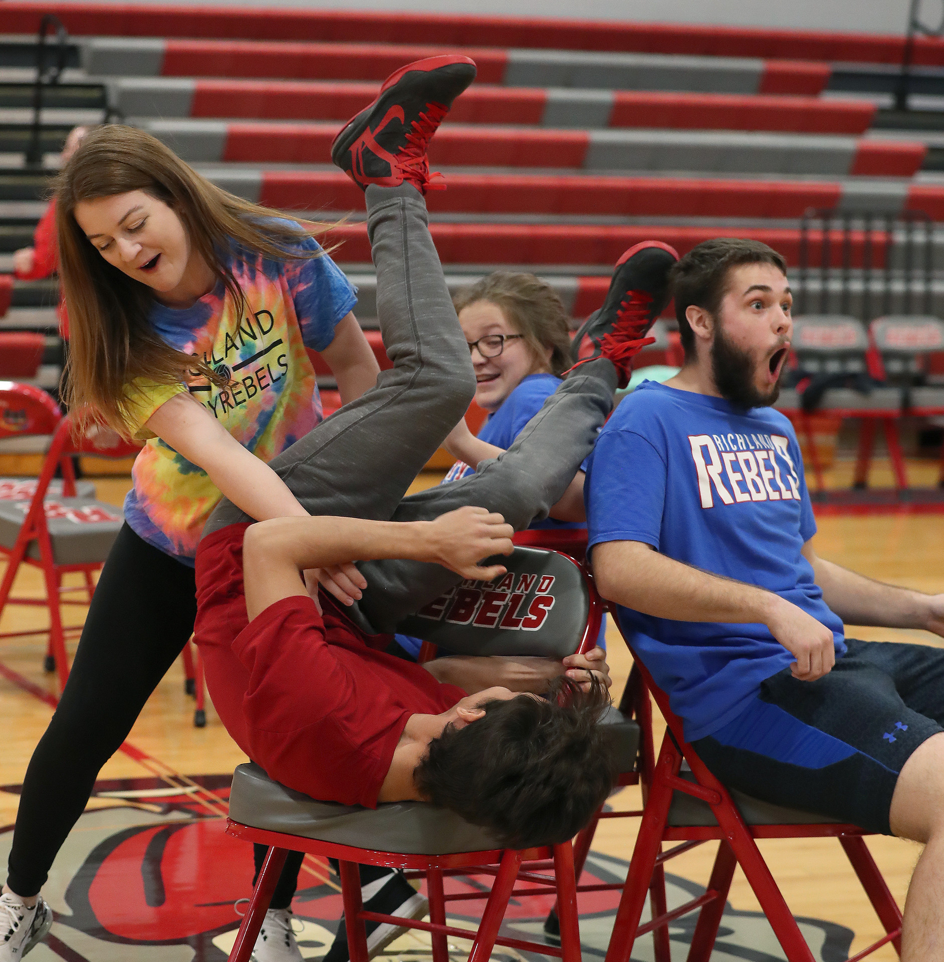 students at a pep assembly playing musical chairs