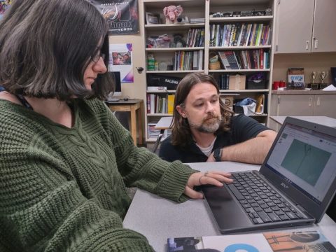 Davis helping a student at her computer. 