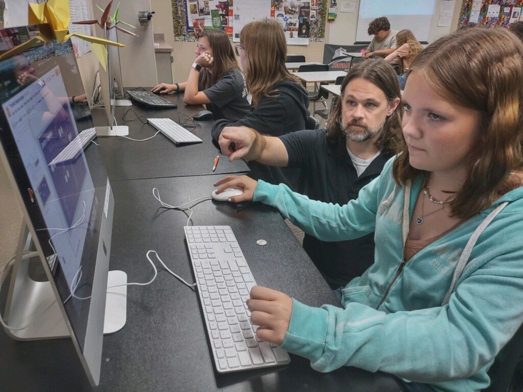 Davis helping a student at her computer
