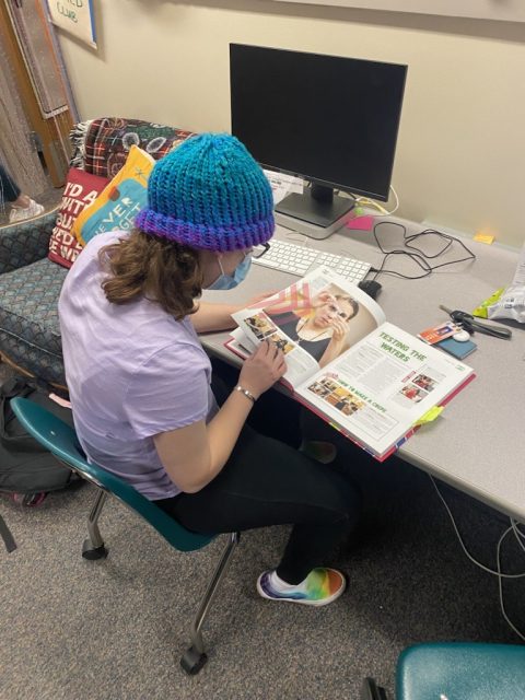Student looking at a yearbook working on layout