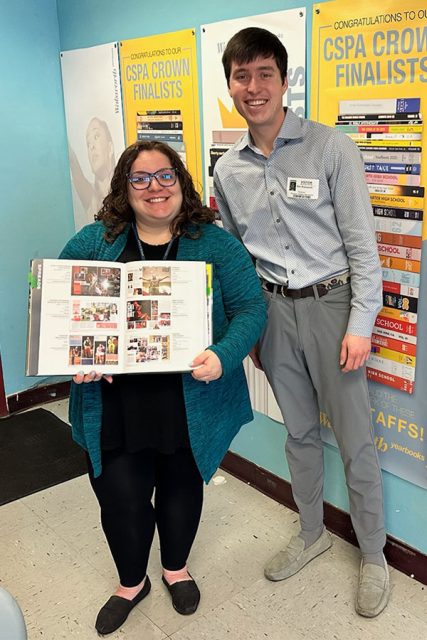 Tripp with student and and open yearbook 