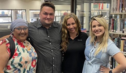 Four Walsworth CSRs standing in a school library posing for a photo. 